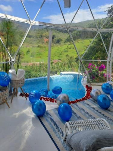 un montón de globos azules en una mesa junto a una piscina en Glamping Villa Luces, en Tocotá