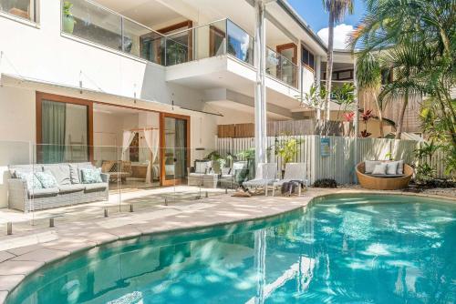 a swimming pool in front of a house at Beachcomber Blue - beachfront villa with pool in Byron Bay