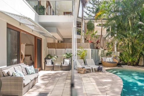 a patio with a couch and a swimming pool at Beachcomber Blue - beachfront villa with pool in Byron Bay