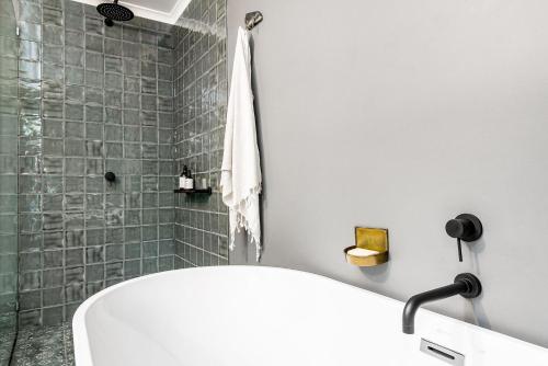 a bathroom with a shower and a tub and a sink at A Perfect Stay - Black Star in Byron Bay