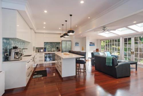 a kitchen and living room with a couch and a table at Camellia House - Elevator Access, Swimming, and Spa Pools in Nelson