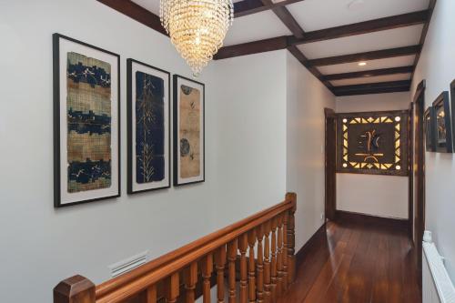 a hallway with pictures on the wall and a chandelier at Camellia House - Elevator Access, Swimming, and Spa Pools in Nelson