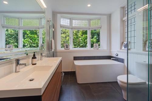 a bathroom with a tub and a sink and a toilet at Camellia House - Elevator Access, Swimming, and Spa Pools in Nelson