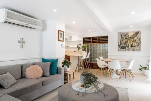 a living room with a couch and a table at Byron Blisshouse - multi-home retreat with pool in Byron Bay
