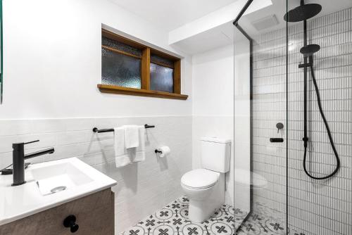 a bathroom with a toilet and a glass shower at Byron Blisshouse - multi-home retreat with pool in Byron Bay