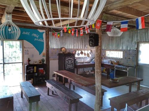 a restaurant with wooden tables and benches and flags at Casa Copada in Punta Del Diablo