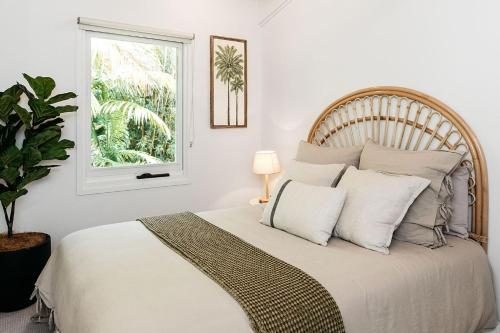 a bedroom with a large bed with a window at Cape Breeze - 5 BR home with headland views in Byron Bay