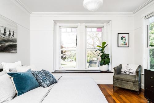 a bedroom with a bed and a chair and a window at A Perfect Stay - Charlottes Web in Bangalow