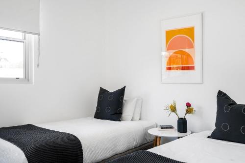 a bedroom with two beds and a table at A Perfect Stay - Clique 1 in Byron Bay