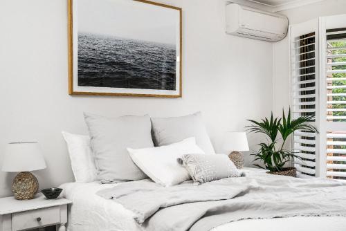ein Schlafzimmer mit einem Bett mit einem Bild an der Wand in der Unterkunft A Perfect Stay - Cooinda in Byron Bay