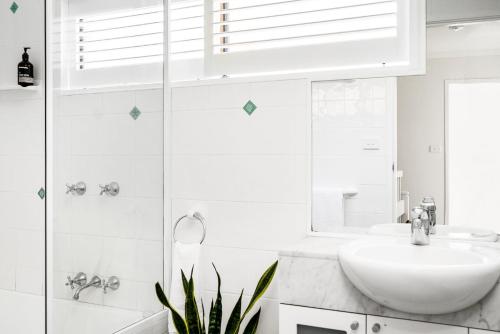 a white bathroom with a sink and a shower at A Perfect Stay - Cooinda in Byron Bay