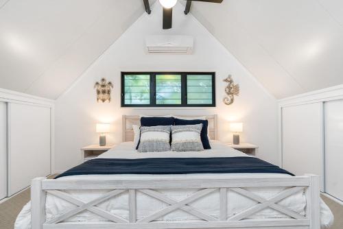 a white bedroom with a large white bed with pillows at A Perfect Stay - Gidgets House and Studio in Byron Bay