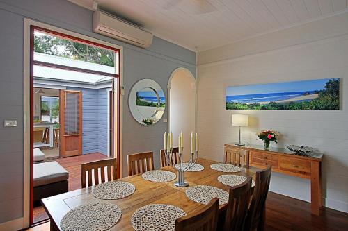 comedor con mesa, sillas y ventana en A Perfect Stay - Harkaway, en Byron Bay