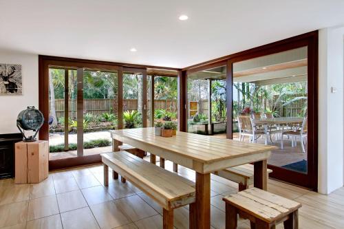 a dining room with a wooden table and benches at A Perfect Stay - Jimmys Beach House in Byron Bay