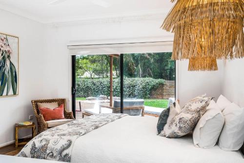 a bedroom with a bed and a large window at A Perfect Stay - Julian Rocks House in Byron Bay