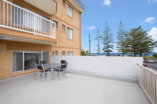 a balcony with a table and chairs next to a building at 2 Camden House in Gold Coast