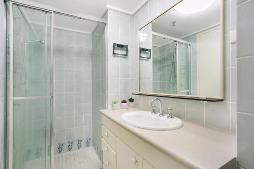 a bathroom with a sink and a shower with a mirror at A Perfect Stay - 23C Imperial Surf in Gold Coast