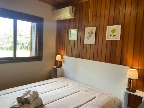 een slaapkamer met een groot wit bed met een raam bij Casa de campo São Bartolomeu in Coronel Pilar