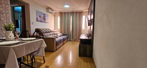 Conforto Urbano, Apartamento Acolhedor في مارينجا: غرفة معيشة مع طاولة وأريكة