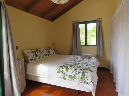 1 dormitorio con cama y ventana en Mill Bay Charmer, en Mangonui