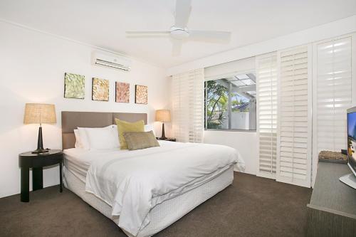 a white bedroom with a bed and a television at A Perfect Stay - La Casetta in Gold Coast