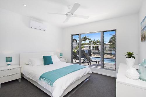 Biała sypialnia z łóżkiem i balkonem w obiekcie A Perfect Stay - Buena Vista w mieście Gold Coast