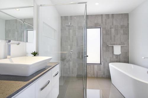 W łazience znajduje się umywalka i przeszklony prysznic. w obiekcie A Perfect Stay - Buena Vista w mieście Gold Coast