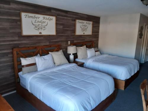 two beds in a hotel room with blue sheets at Timber Ridge Lodge Gatlinburg in Gatlinburg
