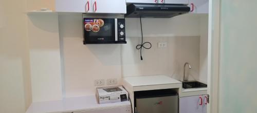 uma pequena cozinha com fogão e micro-ondas em KS RESIDENCES em Manila