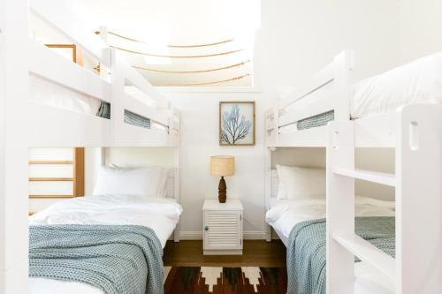 A Perfect Stay - Kia Ora Byron في خليج بايرون: سريرين في غرفة نوم مع سرير بطابقين أبيض