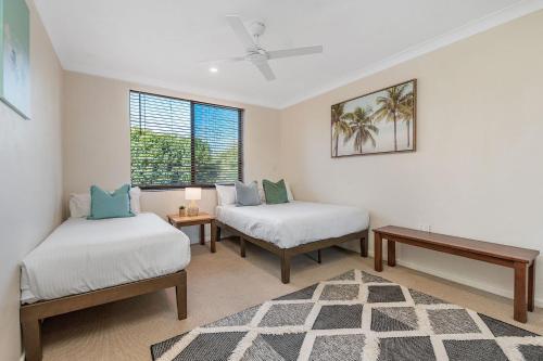 a room with two beds and a table and a window at A Perfect Stay - Lisas on Lawson in Byron Bay