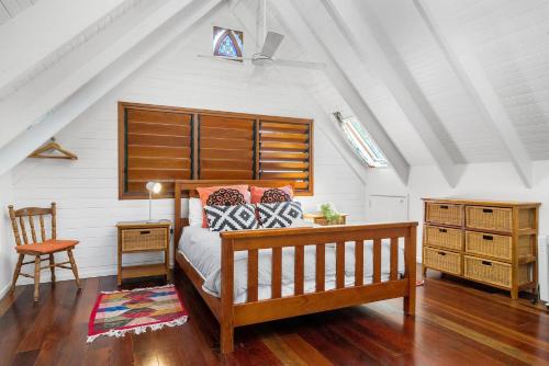 ein Schlafzimmer mit einem Bett, einem Tisch und einem Stuhl in der Unterkunft A Perfect Stay - Longhouse in Byron Bay