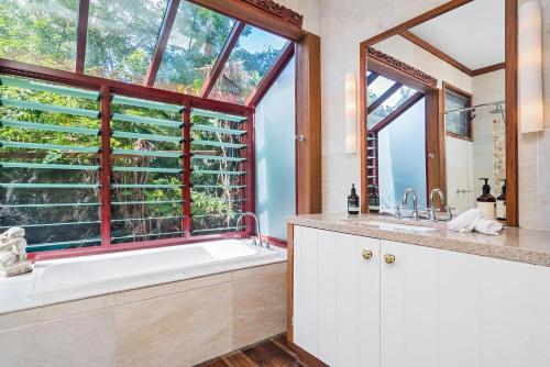 a bathroom with a tub and a large window at A Perfect Stay - Longhouse in Byron Bay