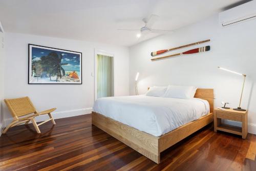 1 dormitorio blanco con 1 cama y 1 silla en A Perfect Stay - Margaret, en Byron Bay