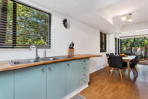 een keuken met een wastafel en een tafel met stoelen bij A Perfect Stay - Mahogany Lodge in Byron Bay