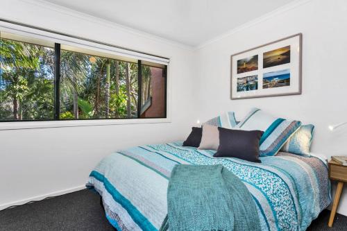 a bedroom with a bed and a large window at A Perfect Stay - Mahogany Lodge in Byron Bay