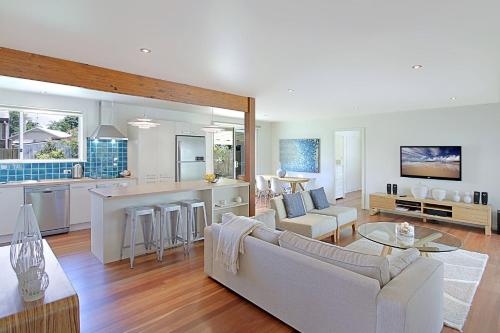 a living room and kitchen with a couch and a table at Mi Casa - stylish beach house near town & surf in Byron Bay