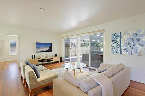 a living room with a couch and a table at Mi Casa - stylish beach house near town & surf in Byron Bay
