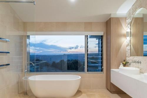 a bathroom with a tub and two sinks and a large window at A Perfect Stay - Miren Estate in Federal