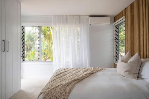 a bedroom with a white bed with a window at Miren Estate - lavish hinterland estate with pool in Federal