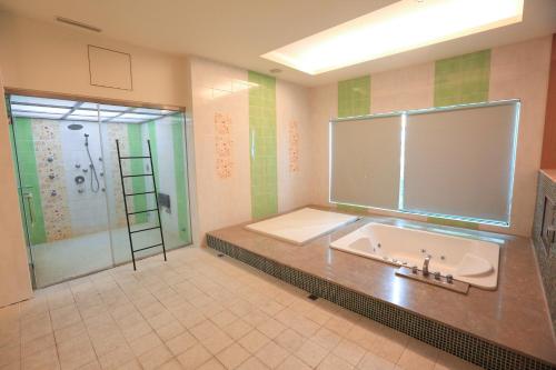 a bathroom with a tub and a shower and a sink at Moon Area Motel in Douliu