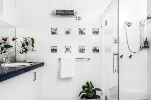 a white bathroom with a shower and a sink at A Perfect Stay in Ewingsdale