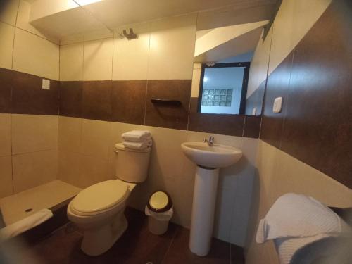 a bathroom with a toilet and a sink at PAQARIQ INN HOTEL in Machu Picchu