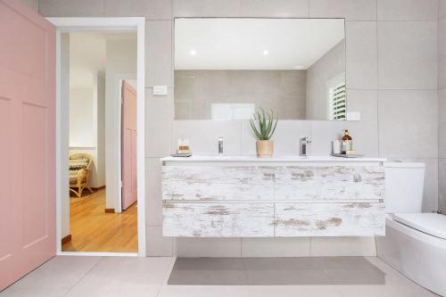 a white bathroom with a sink and a toilet at A Perfect Stay - Pompano House Byron Bay in Suffolk Park