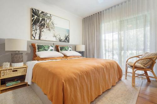 a bedroom with a bed and a chair and a window at A Perfect Stay - Pompano House Byron Bay in Suffolk Park