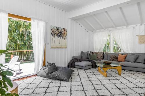 a living room with a couch and a table at San Juan Surfers Cottage - prime Byron location in Byron Bay