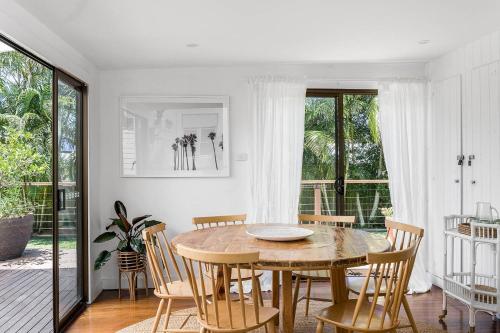 a dining room with a wooden table and chairs at San Juan Surfers Cottage - prime Byron location in Byron Bay