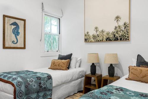 1 Schlafzimmer mit 2 Betten und einem Fenster in der Unterkunft A Perfect Stay - San Juan Surfers Cottage in Byron Bay