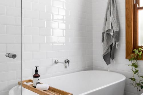 a white bath tub in a bathroom with a window at A Perfect Stay - San Juan Surfers Cottage in Byron Bay