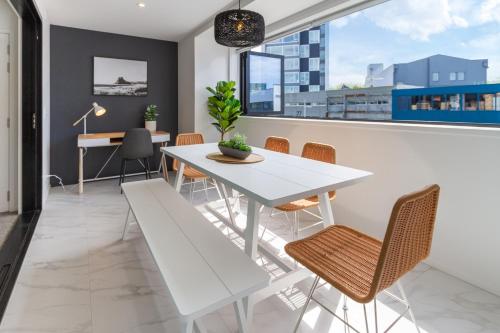 a white table and chairs in a room with a window at CBD Gem: Walk to everything, 3 bedroom 2 bath in Christchurch